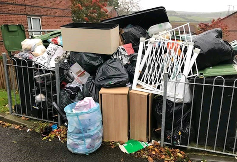 Waste and fly-tipping dumped around a communal bin area