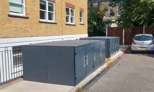 Communal bike lockers outside refurbished apartment block